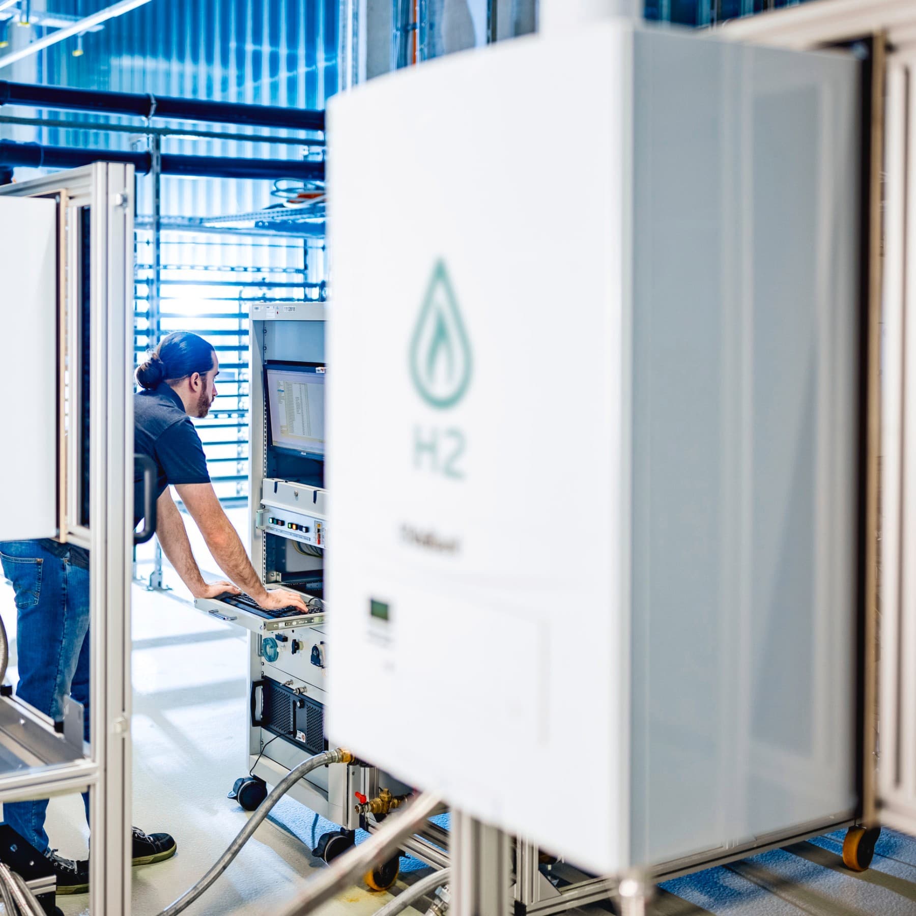 Installateur auf einem Prüfstand überprüft Daten aus einem Testlauf mit Wasserstoff