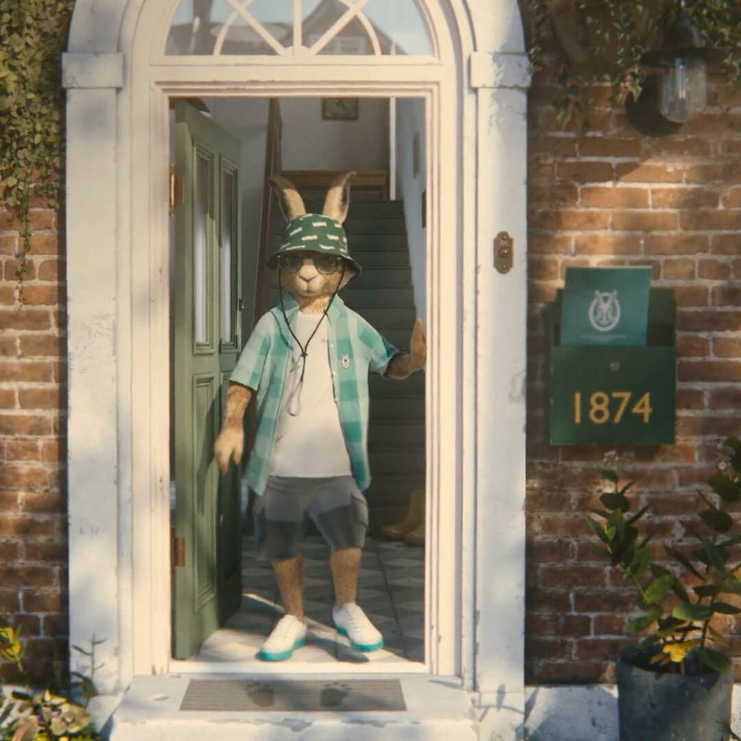 Vaillant Hare steht in einer Haustür und trägt einen Sonnenhut.