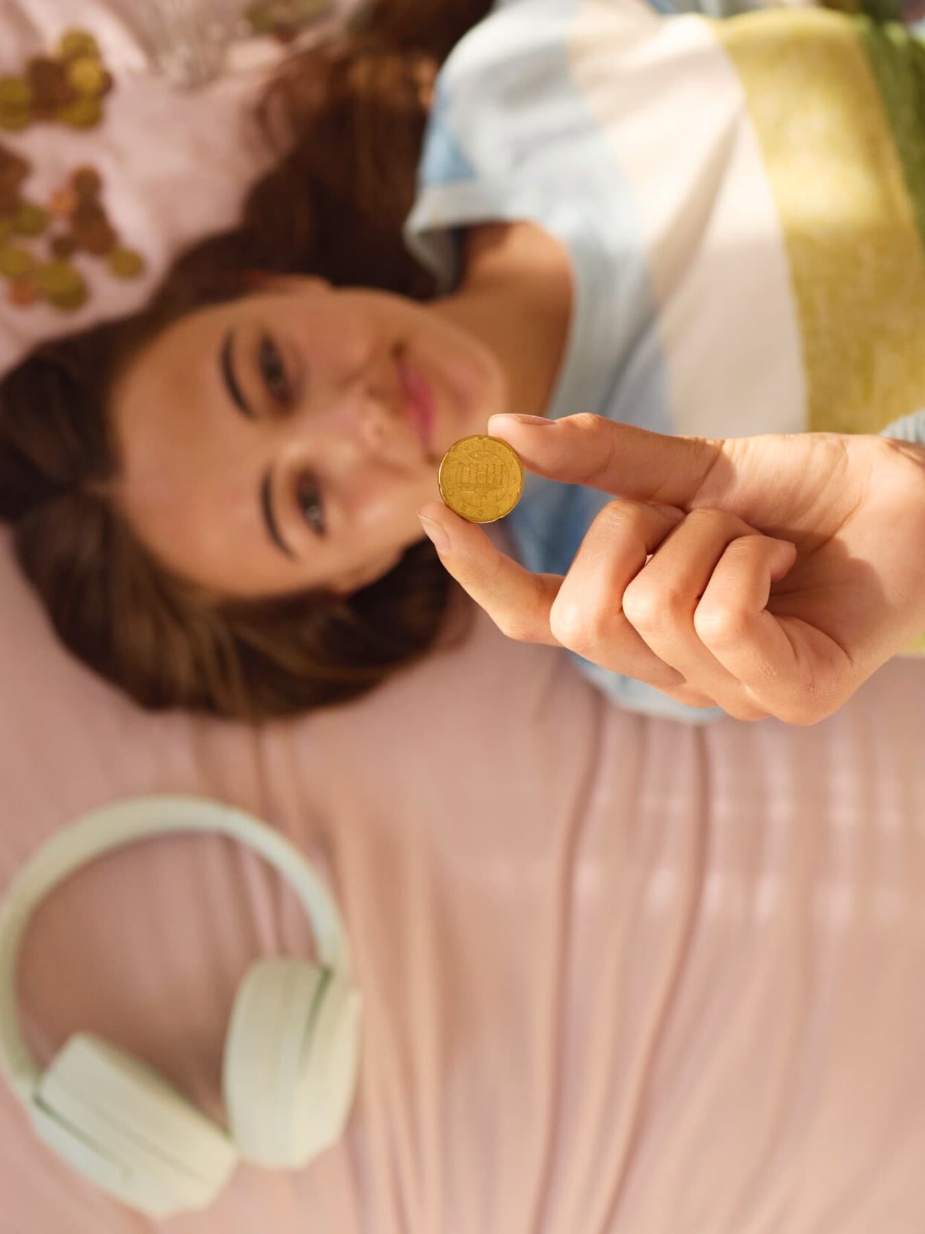 Mädchen zählt Geld auf dem Bett.