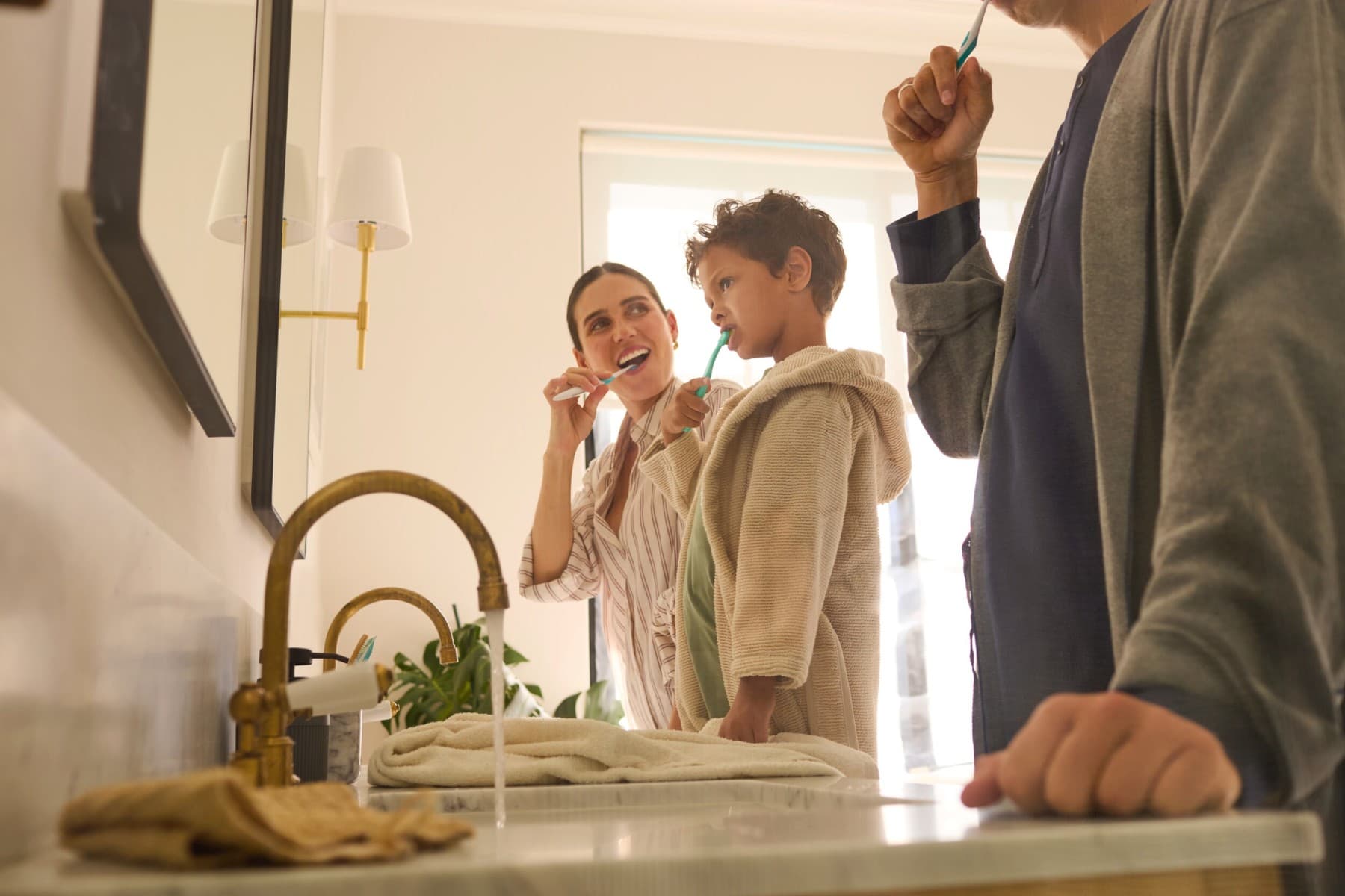 Eine Familie putzt sich im Badezimmer die Zähne.