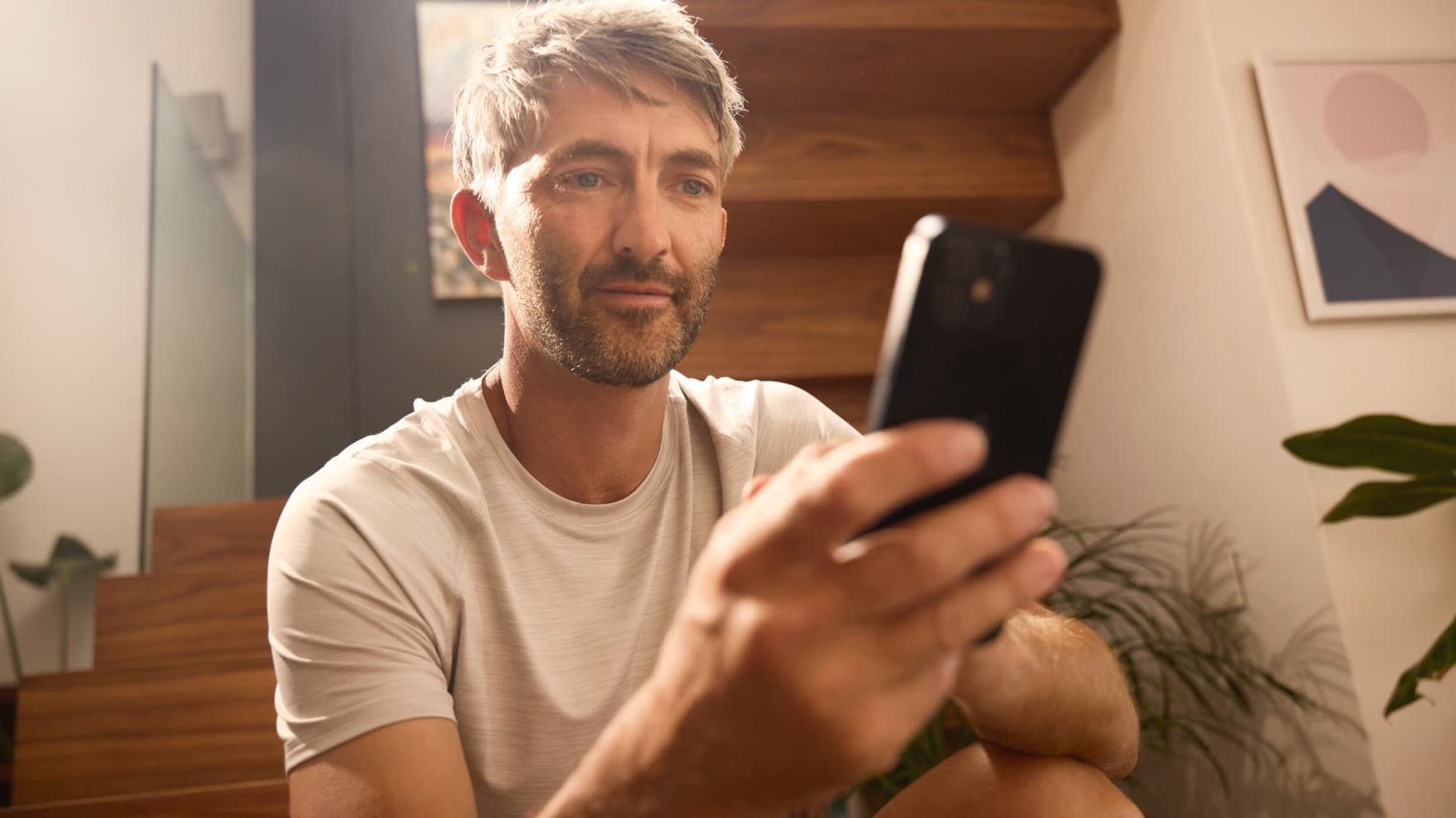 Der Mann steuert seine Heizungsanlage über eine App.
