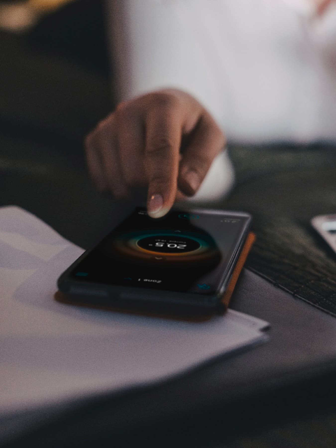 Hand tippt auf ein Handy auf dem Vaillant App zu sehen ist