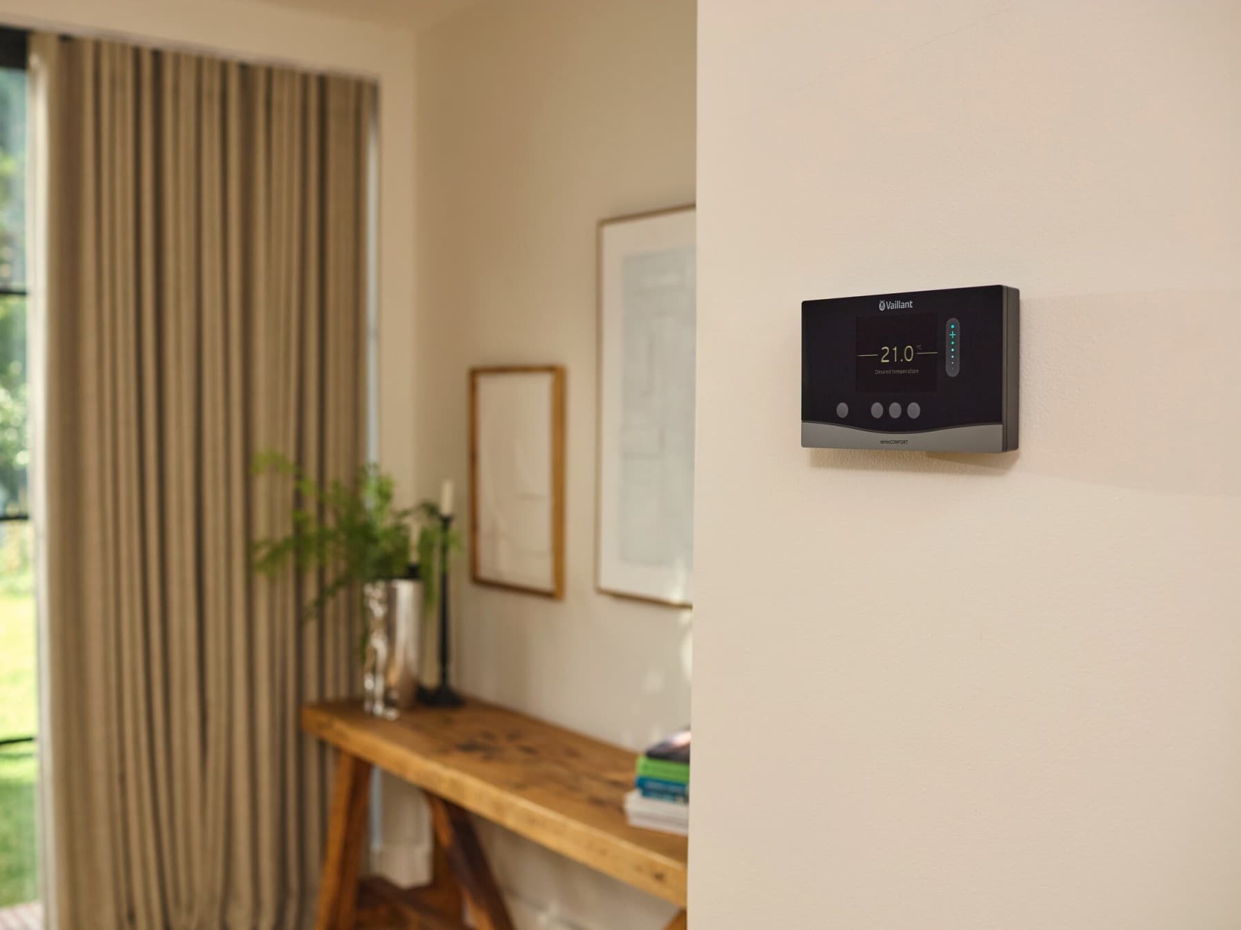 Ein modernes Vaillant Thermostatgerät an einer Wand im Wohnzimmer.