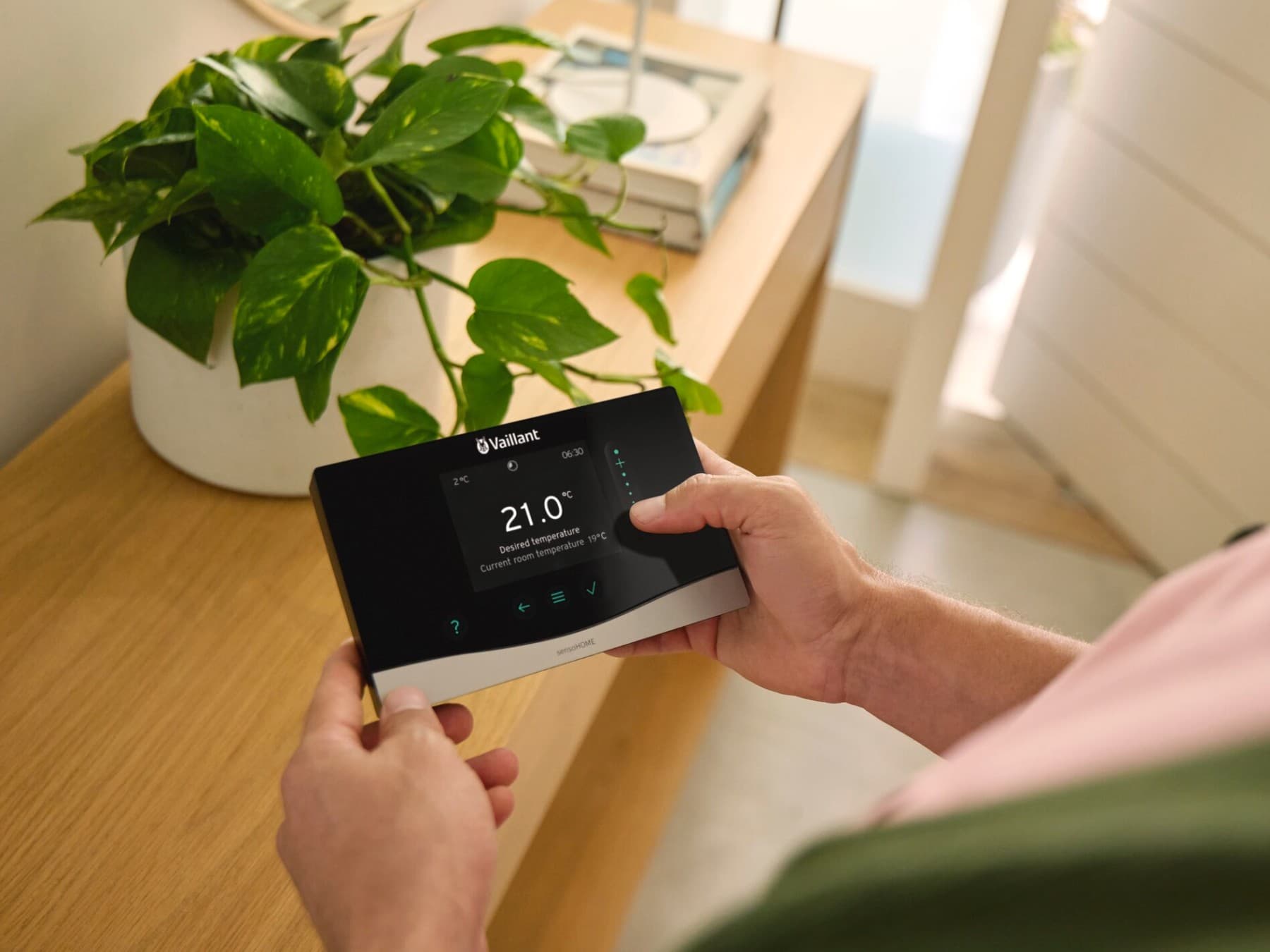 Mann mit der Systemsteuerung sensoCOMFORT in der Hand