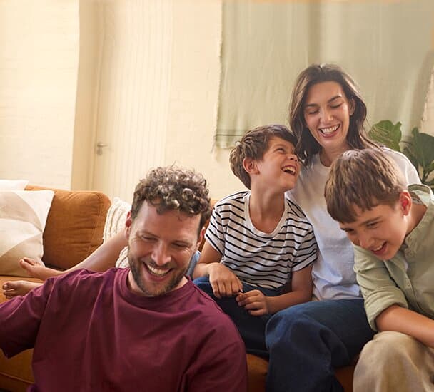 Eine Familie sitzt auf dem Sofa im Wohnzimmer