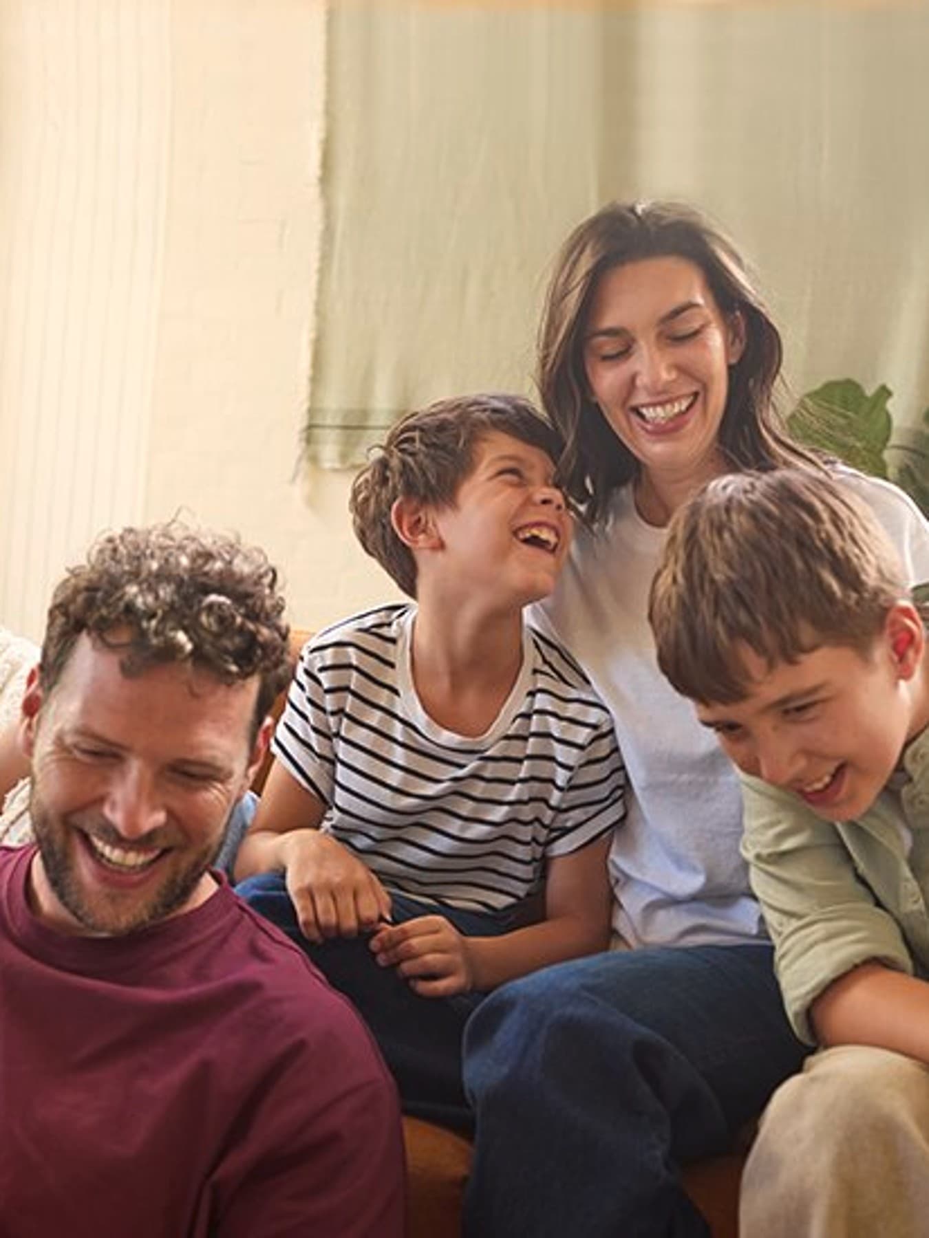 Familie lacht im Wohnzimmer