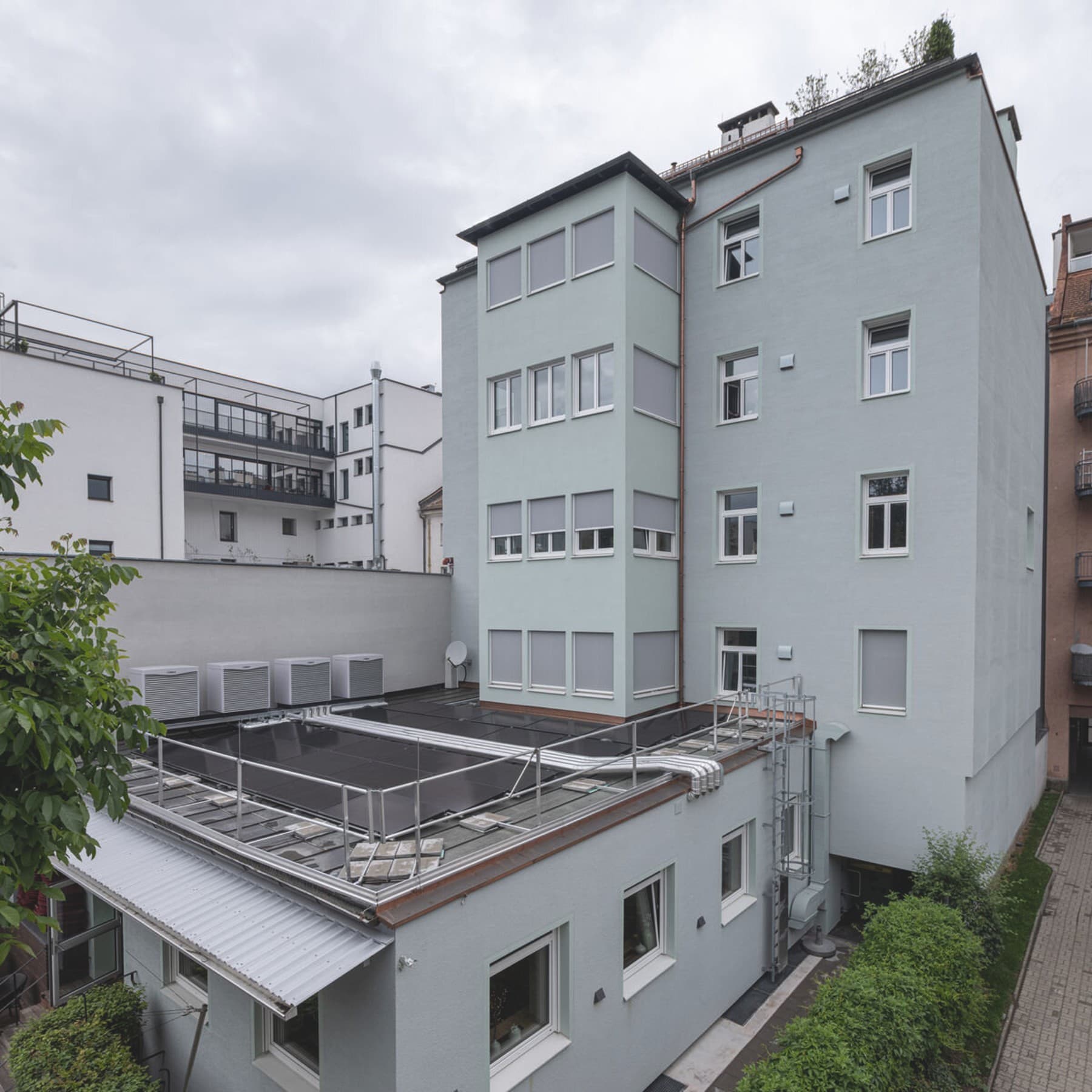 Vier Luft-Wärmepumpen Außengeräte und ein Mehrparteienhaus