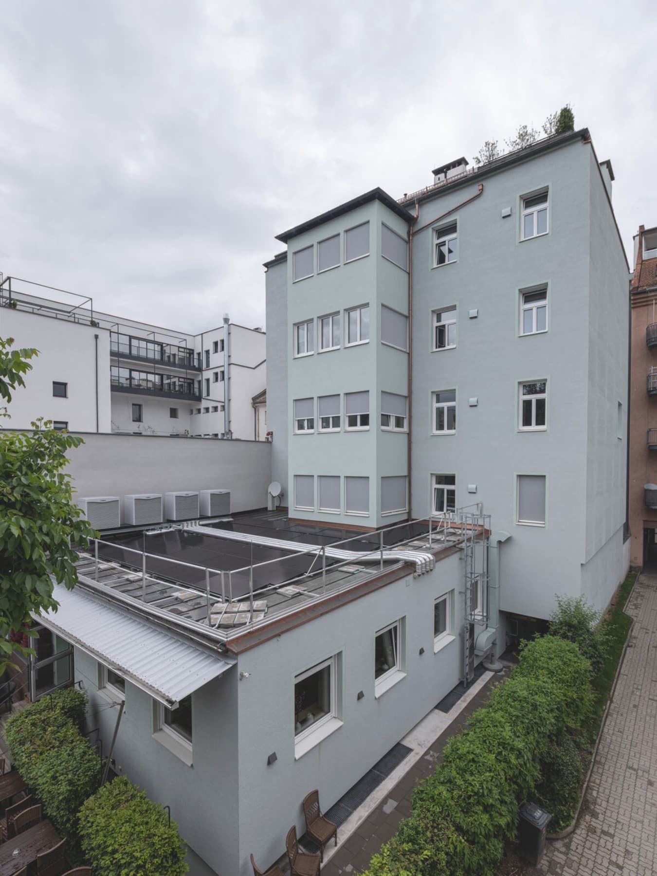 Vier Luft-Wärmepumpen Außengeräte und ein Mehrparteienhaus