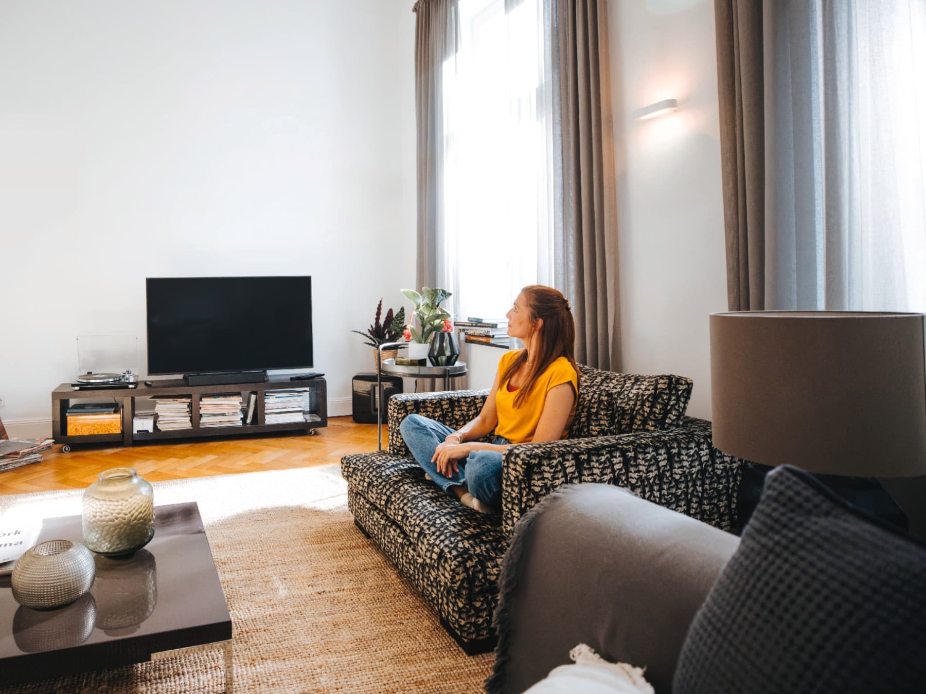 Frau in einer Wohnung auf einem Sofa