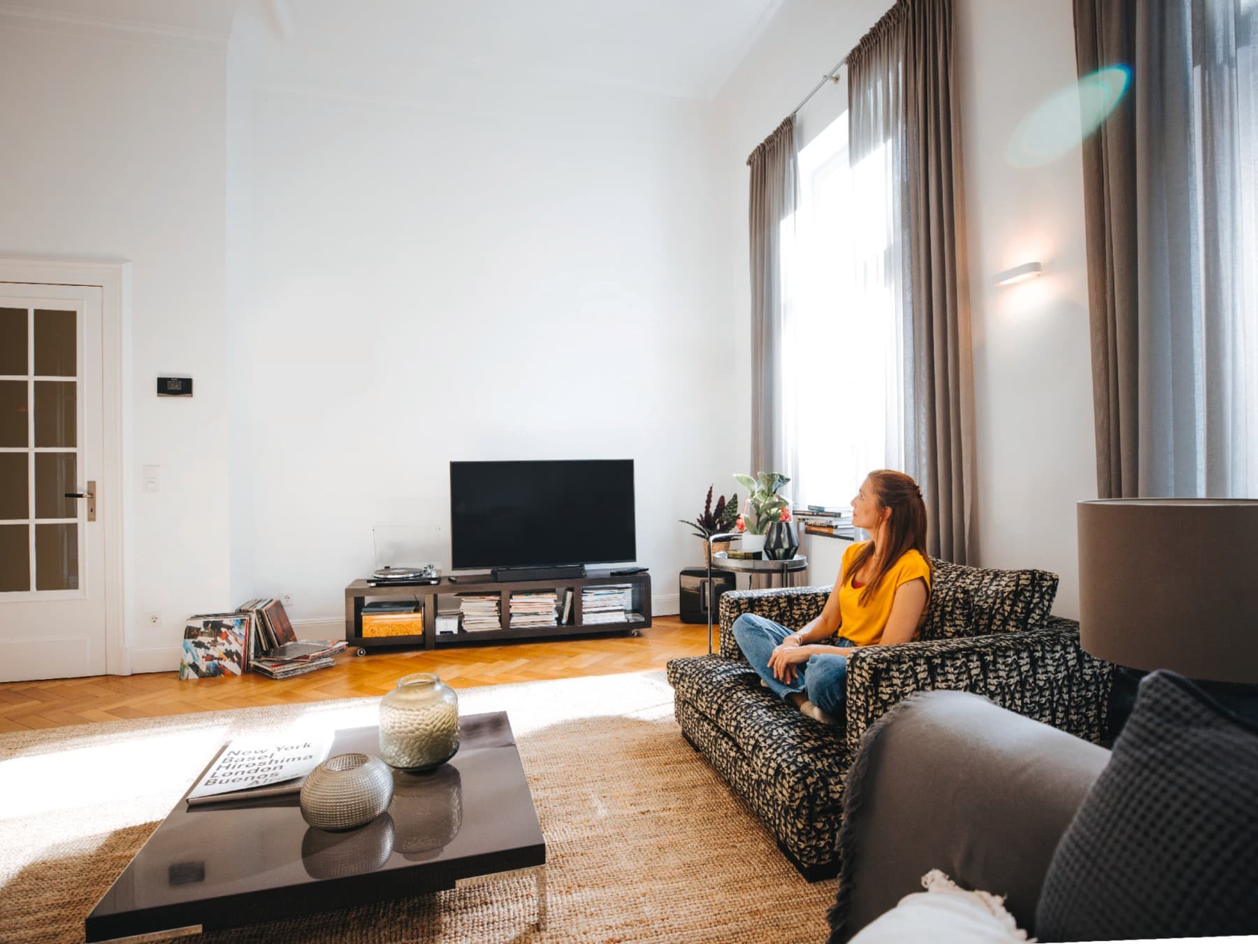 Frau sitzt auf ihrem Sofa und genießt die Ruhe und Stille bei perfekter Temperatur.