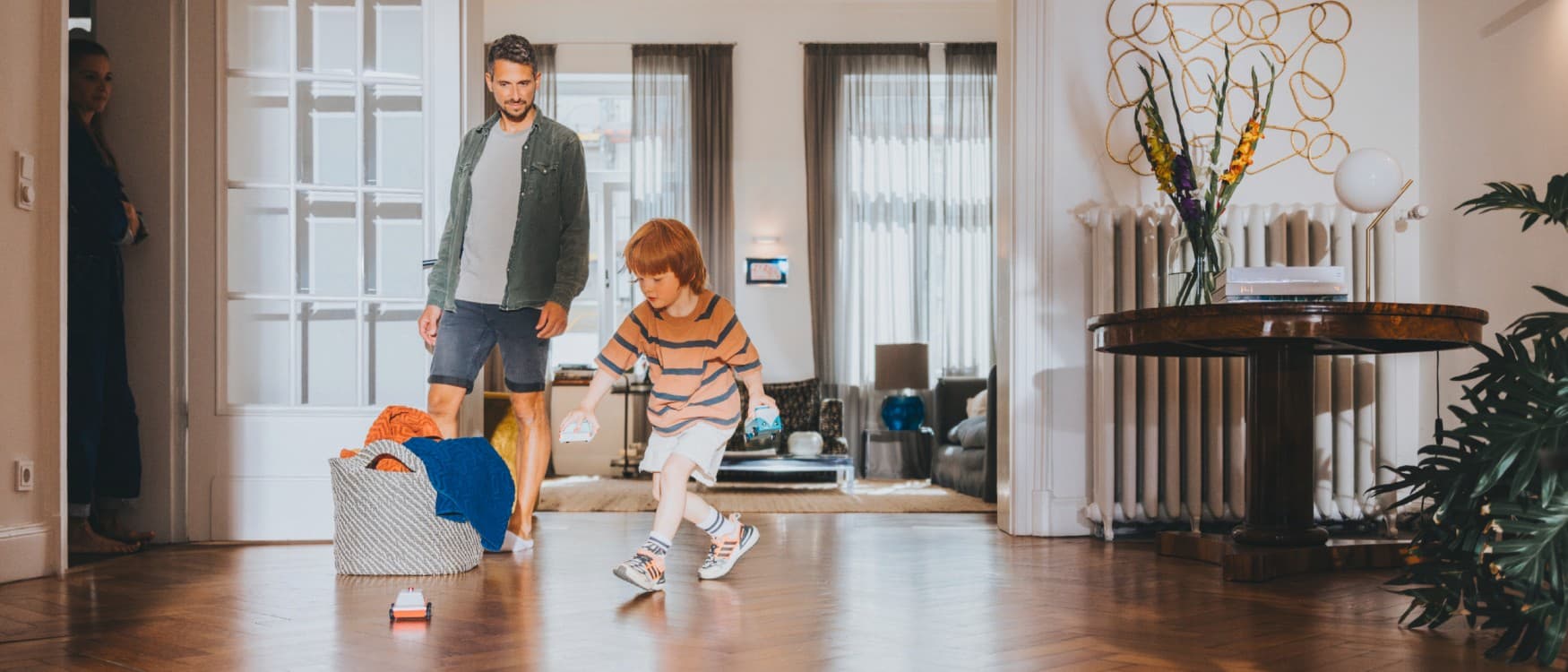Der Vater beobachtet seinen Sohn beim Spielen im Wohnzimmer.