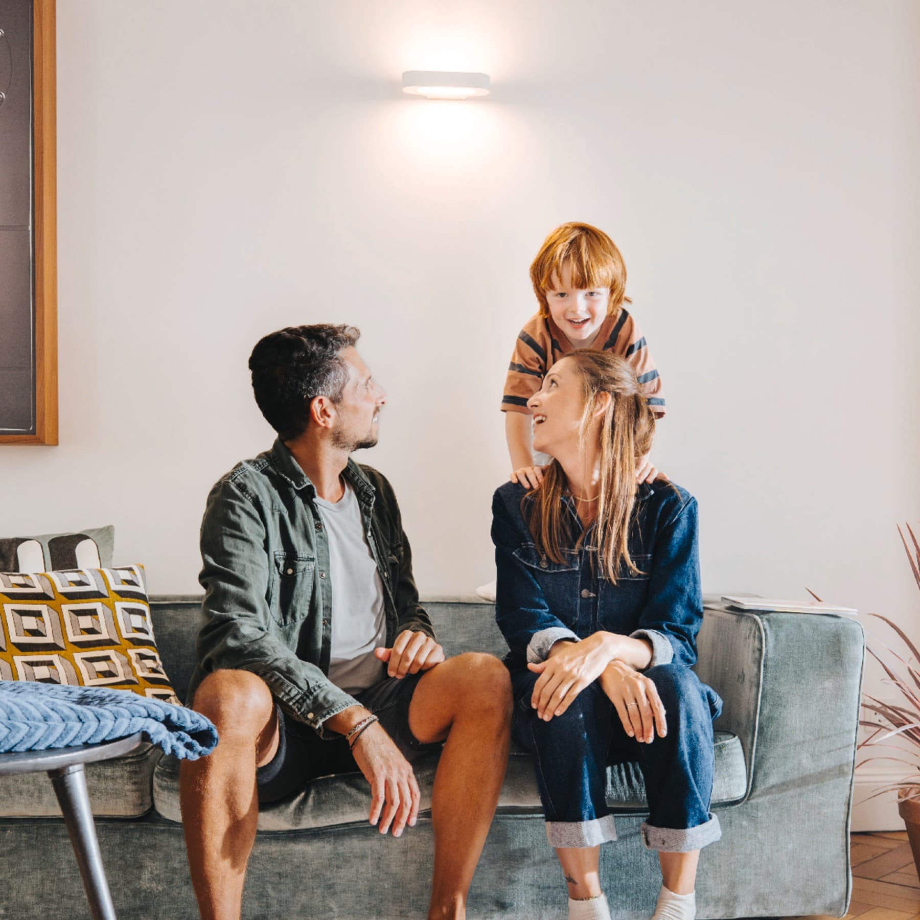 Familie sitzt auf Sofa im Wohnzimmer