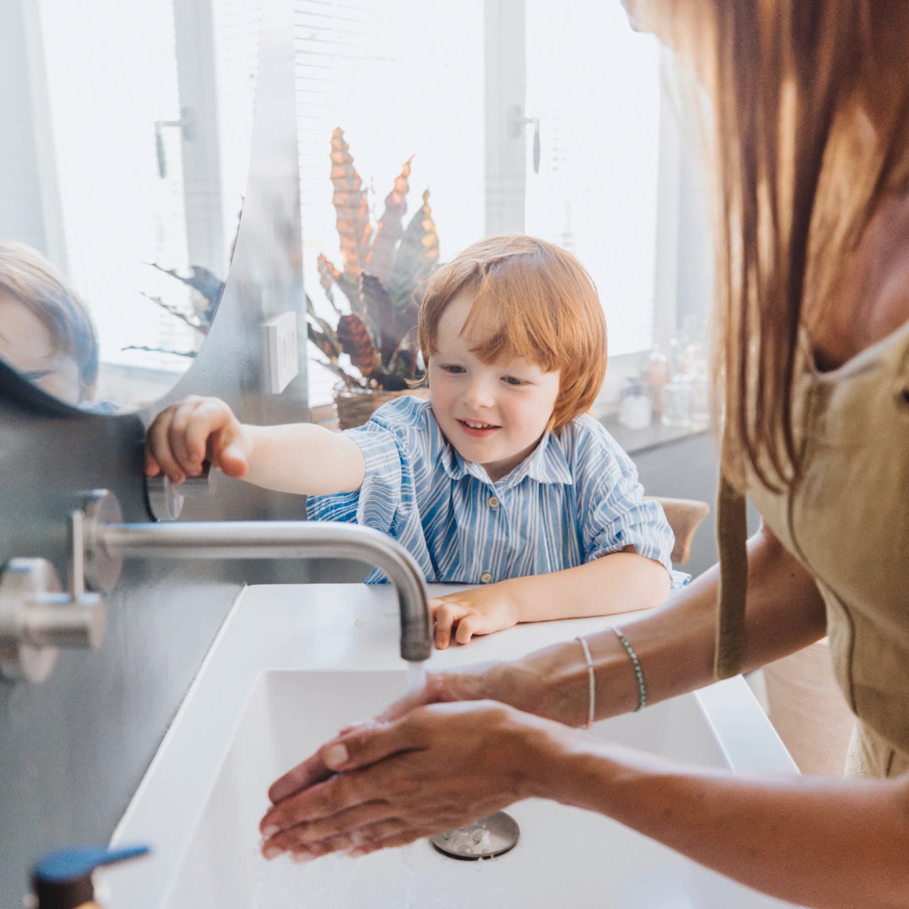Ein Junge und seine Mutter waschen sich die Hände.