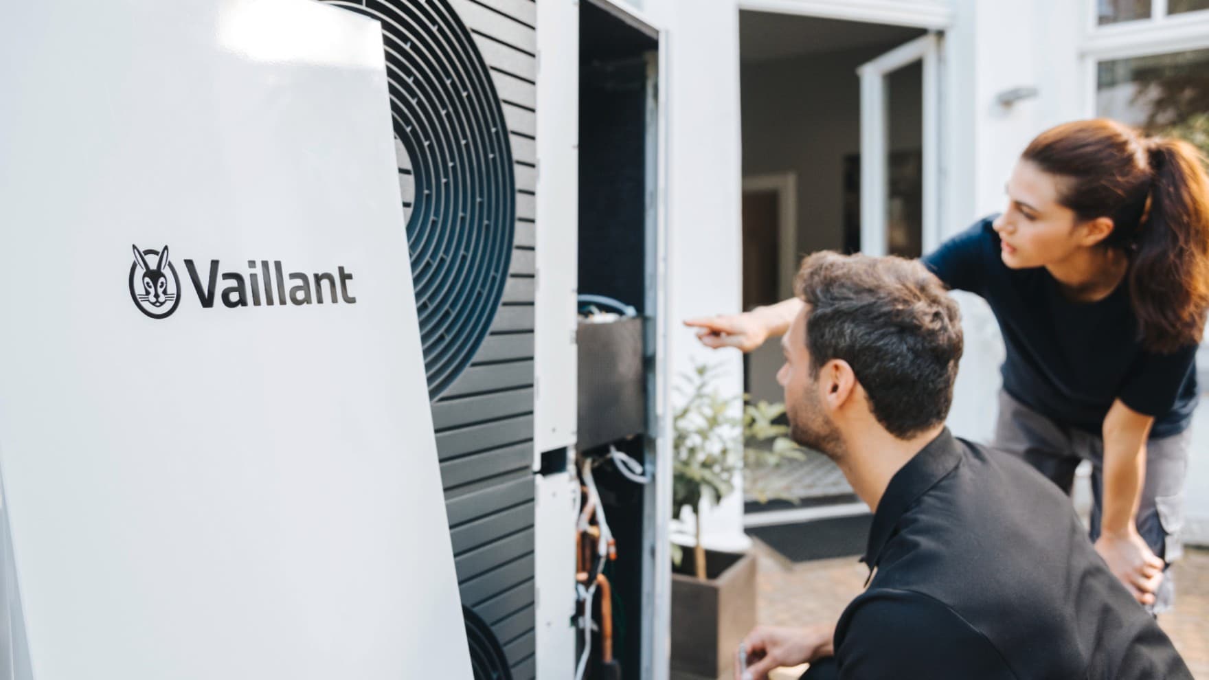 Installateure stehen vor einer offenen Wärmepumpe