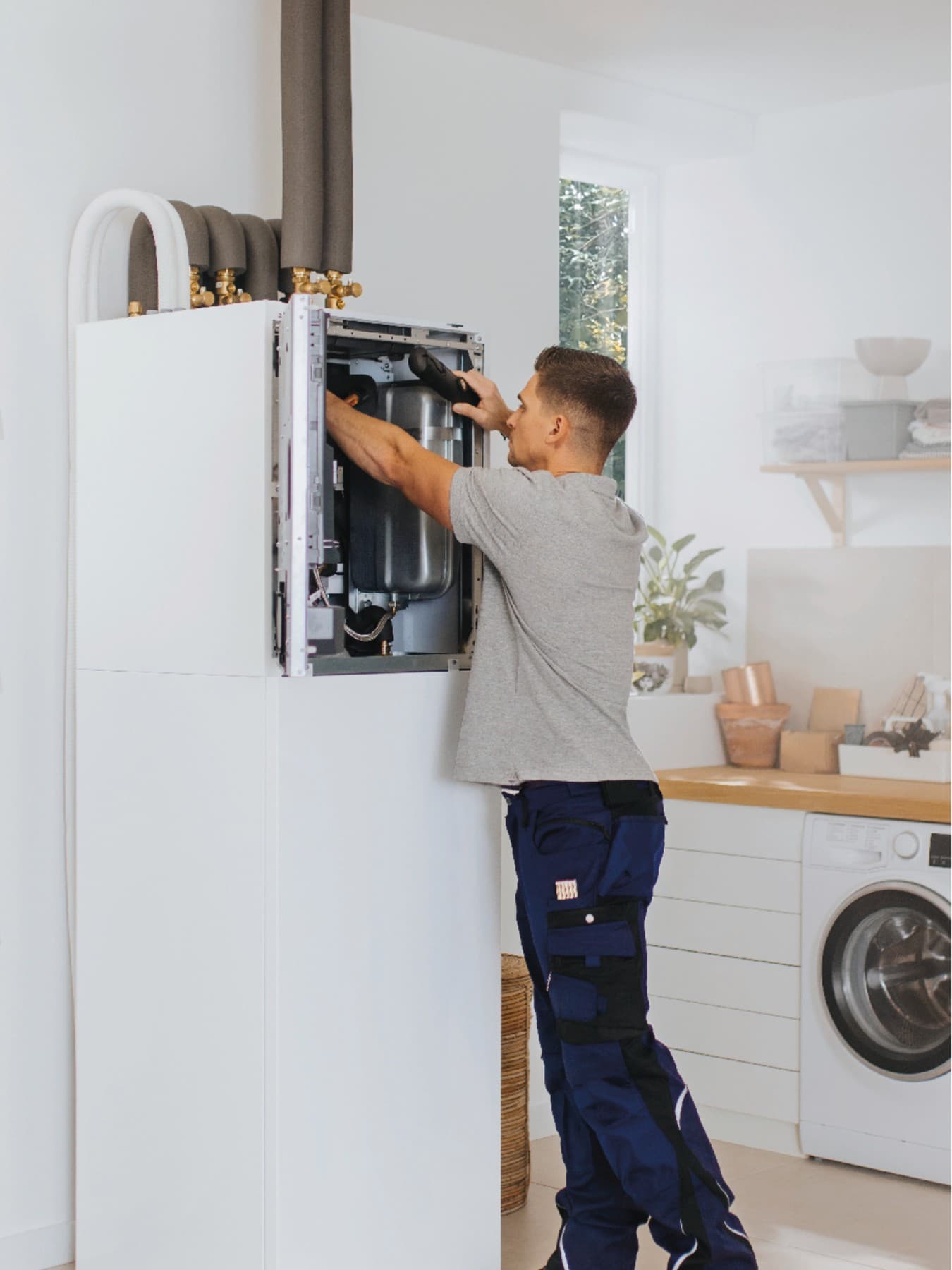 Installateur arbeitet an einer Inneneinheit einer Wärmepumpe