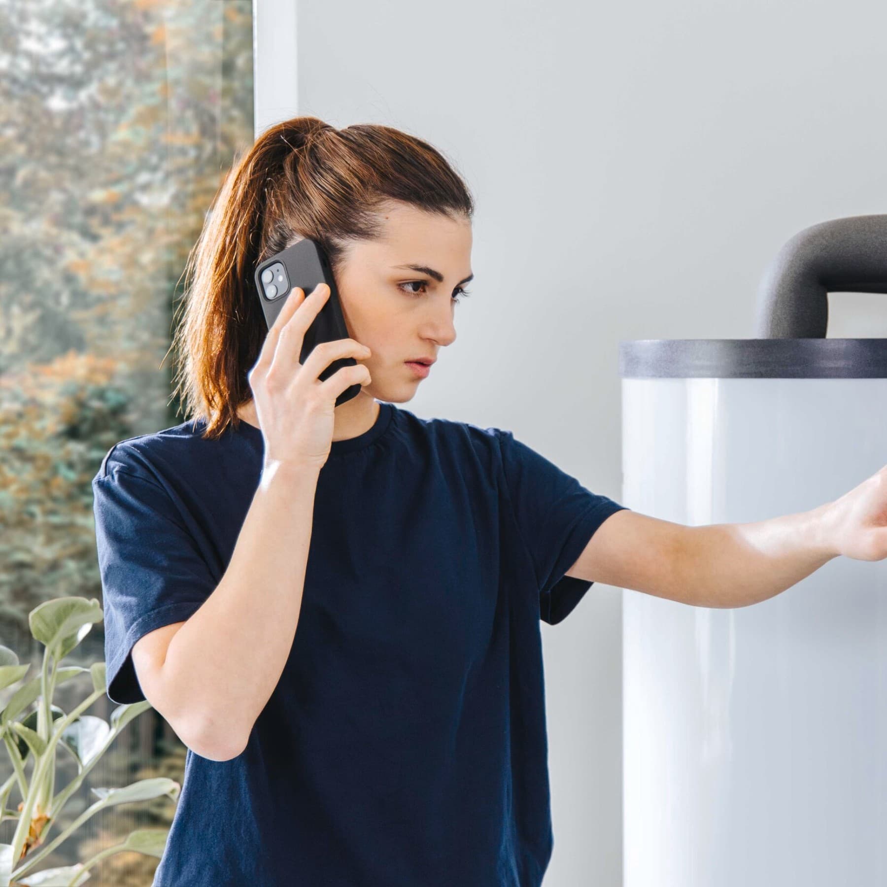Technikerin telefoniert während sie an einem Gerät steht