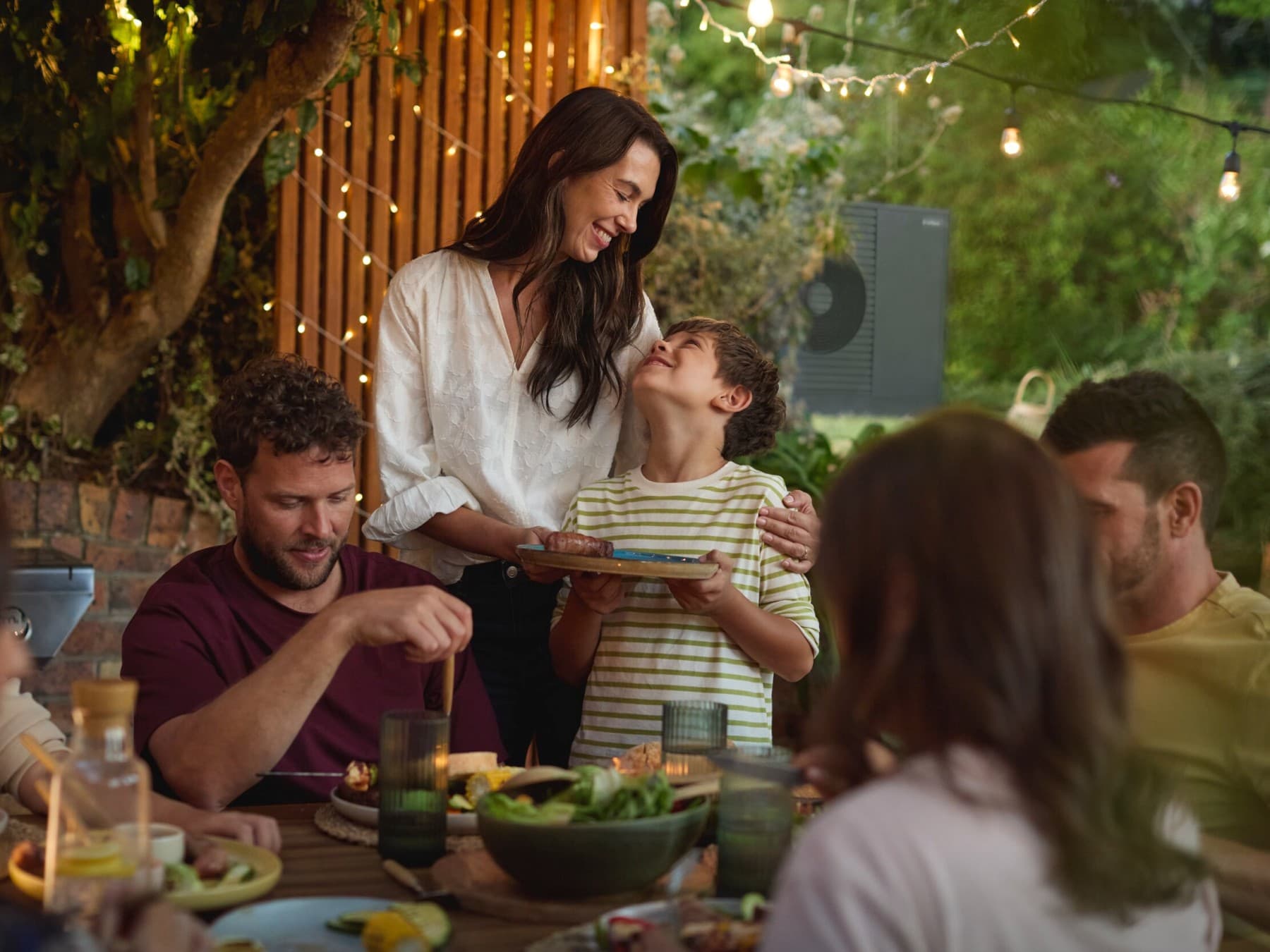 Familie genießt mit Freunden ein Barbecue im Garten