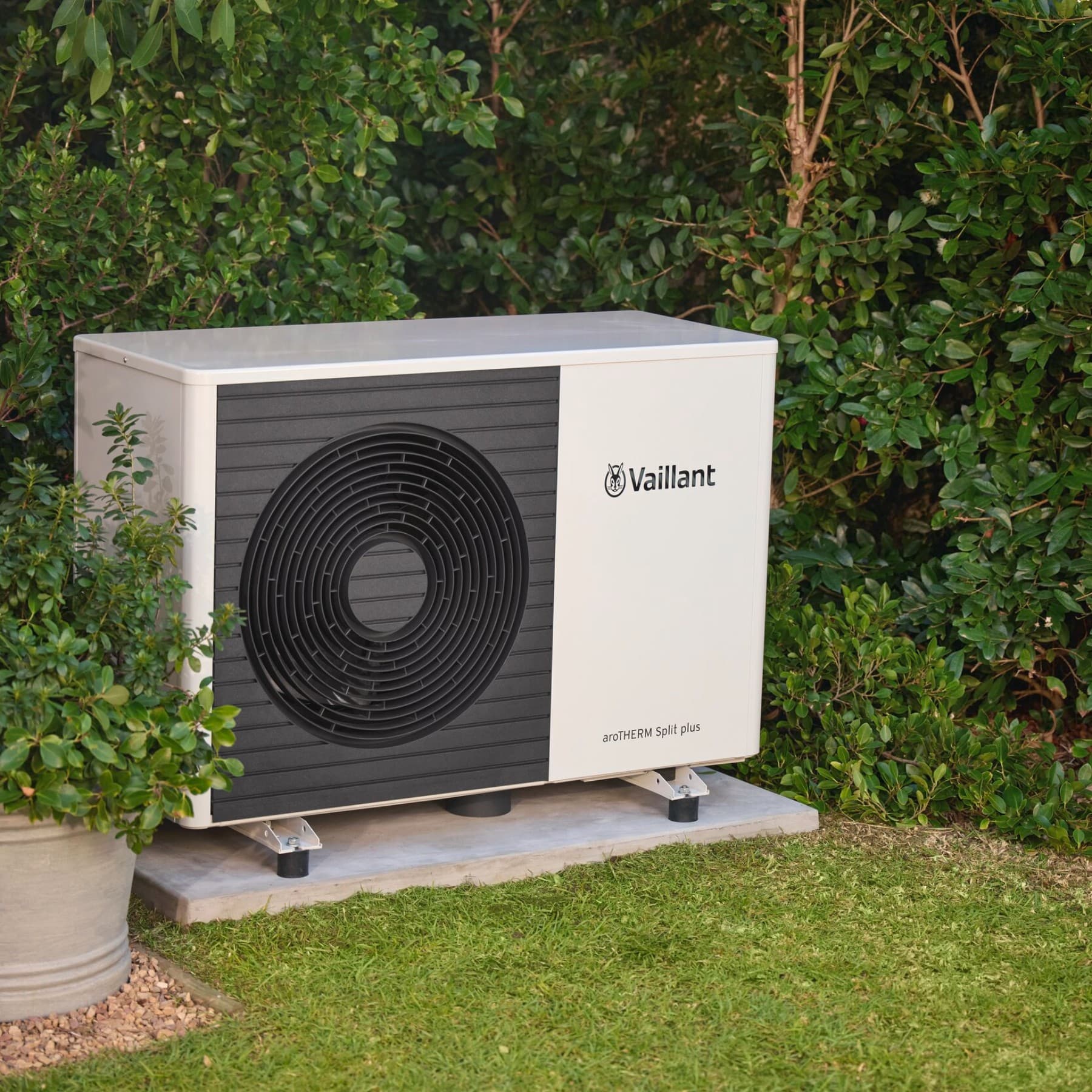 Wärmepumpe vor der Gartenhecke