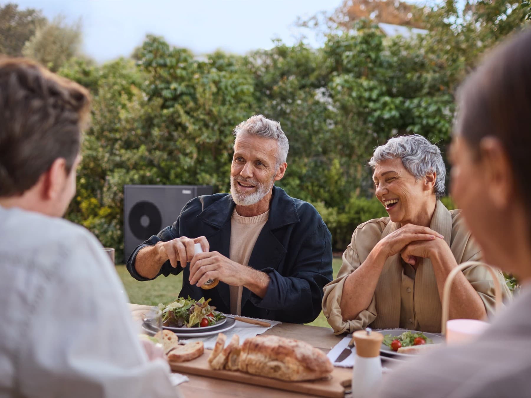 Menschen, die in ihrem Garten essen und die Stille ihrer Wärmepumpe genießen.