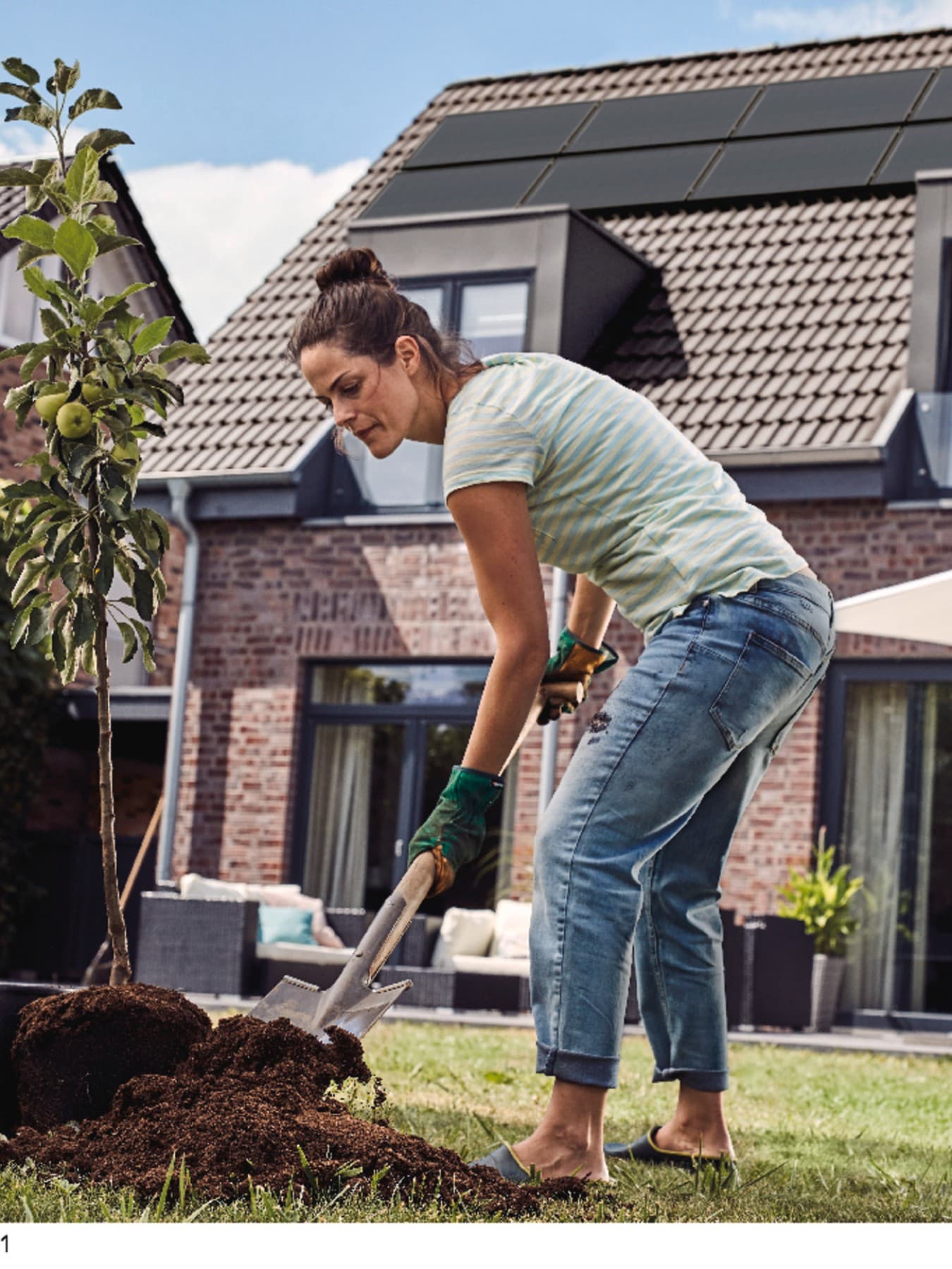 Frau arbeitet im Garten und Pflanzt einen Baum