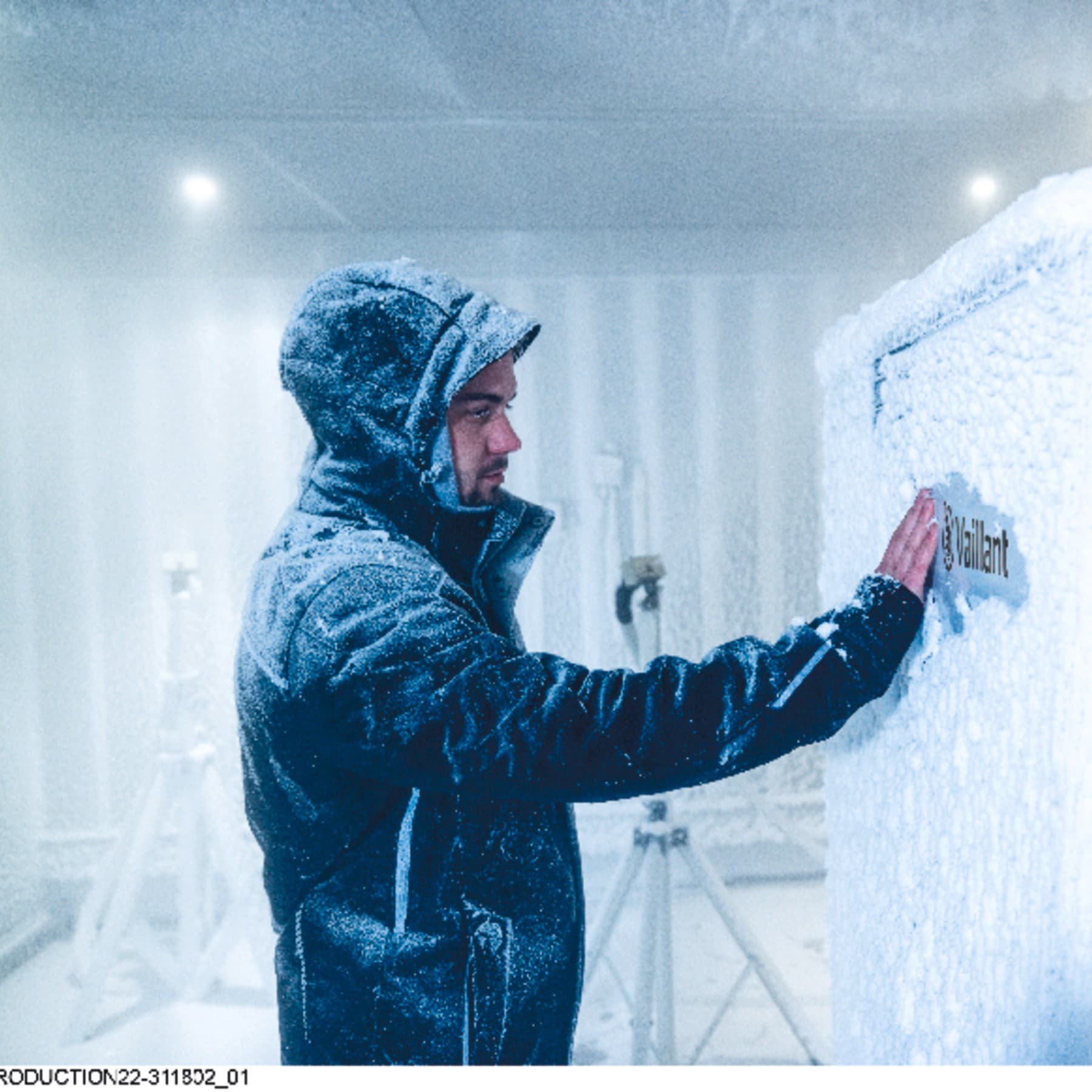Techniker räumt Schnee von Vaillant Wärmepumpe in einer Kühlkammer
