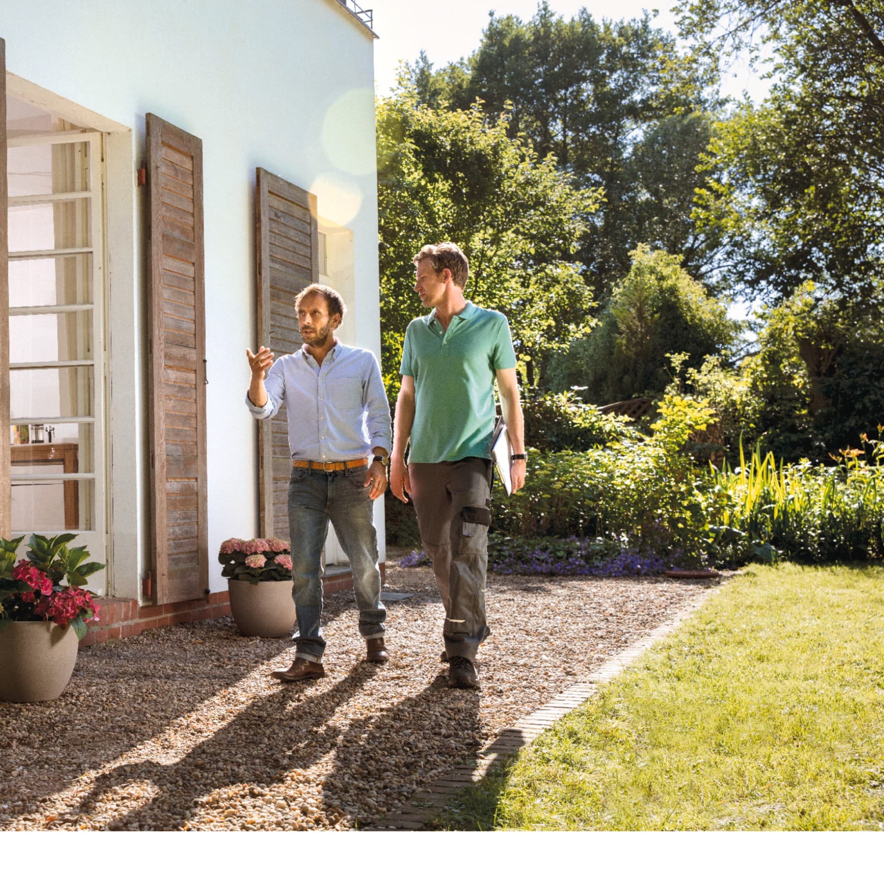 Techniker mit Kunde bei Begehung im Garten