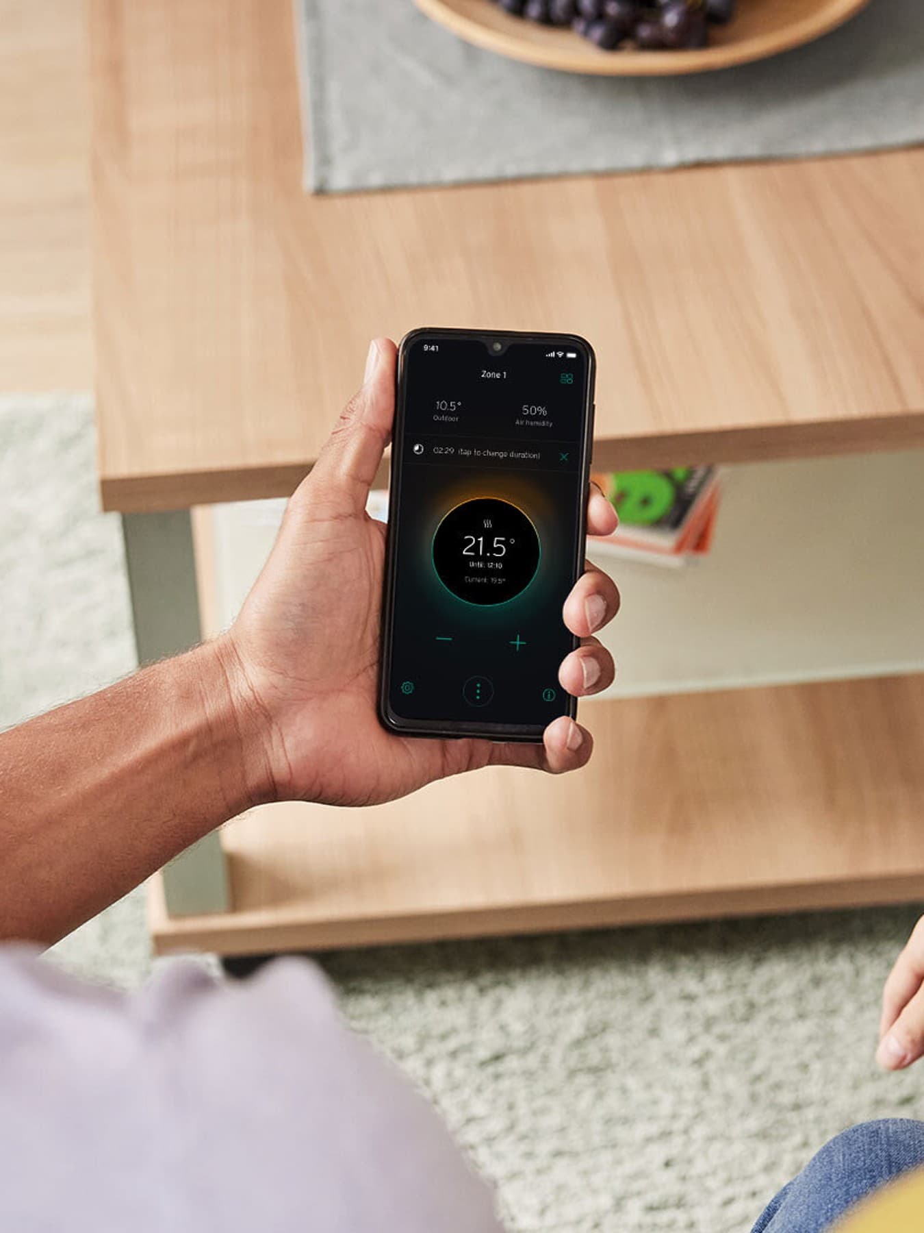 Ein Mann sitzt neben einer Frau, der die myVaillant App auf seinem Smartphone bedient.