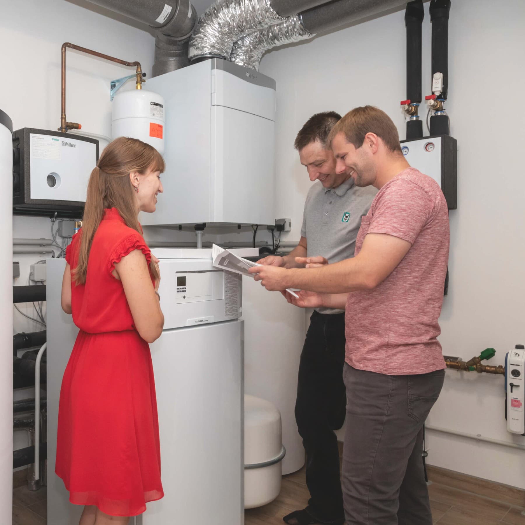 Familie im Heizkeller vor Vaillant Geräten