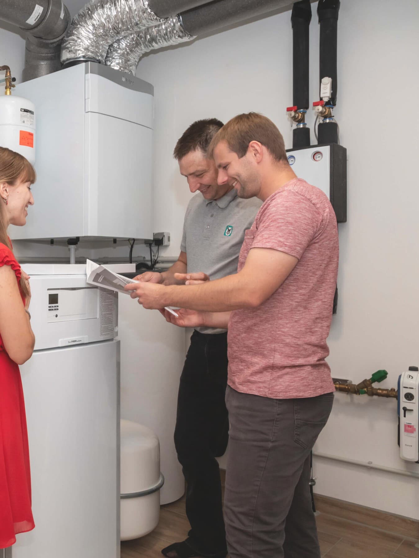 Familie im Heizkeller vor Vaillant Geräten