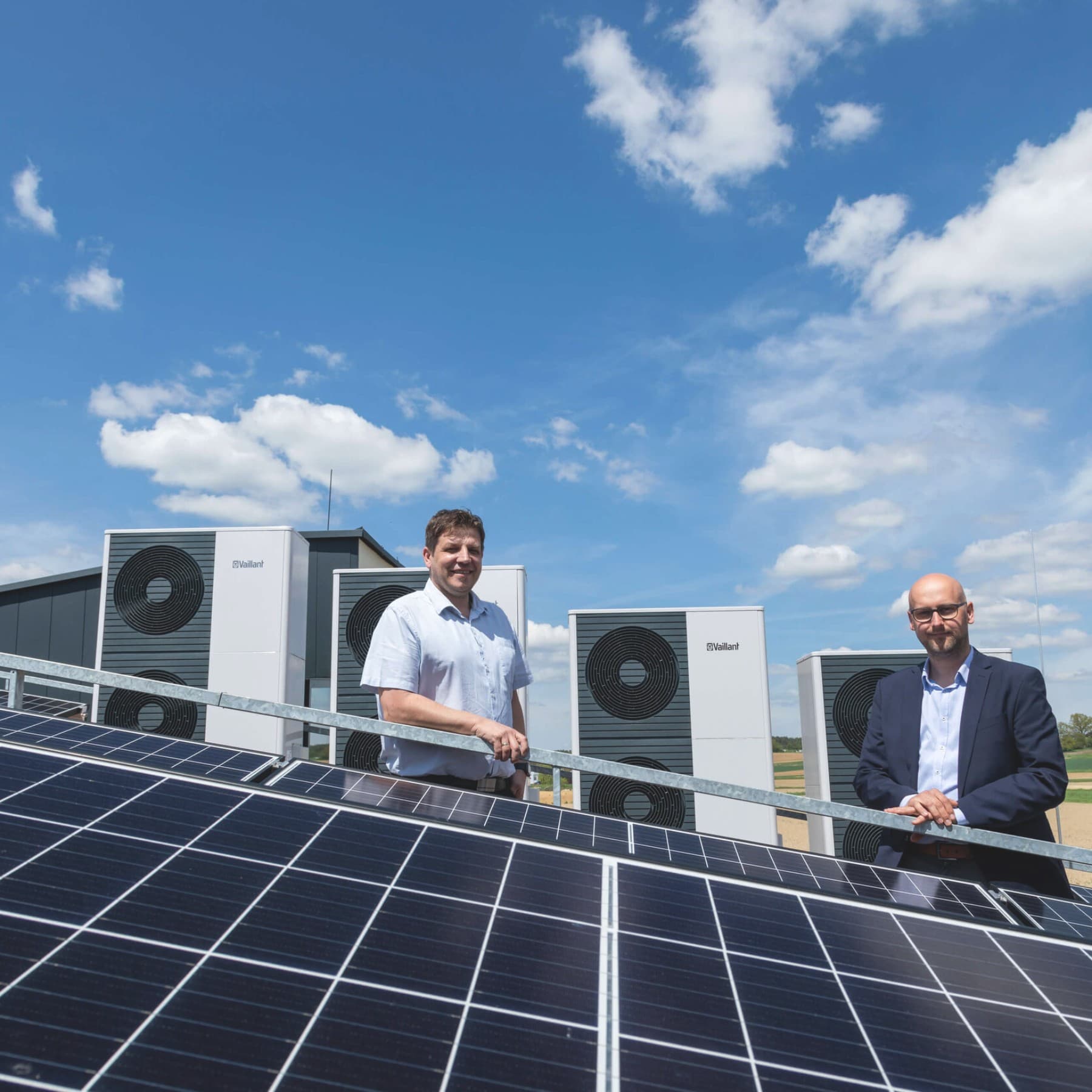 Mann vor Vaillant Wärmepumpe und hinter PV Anlagen