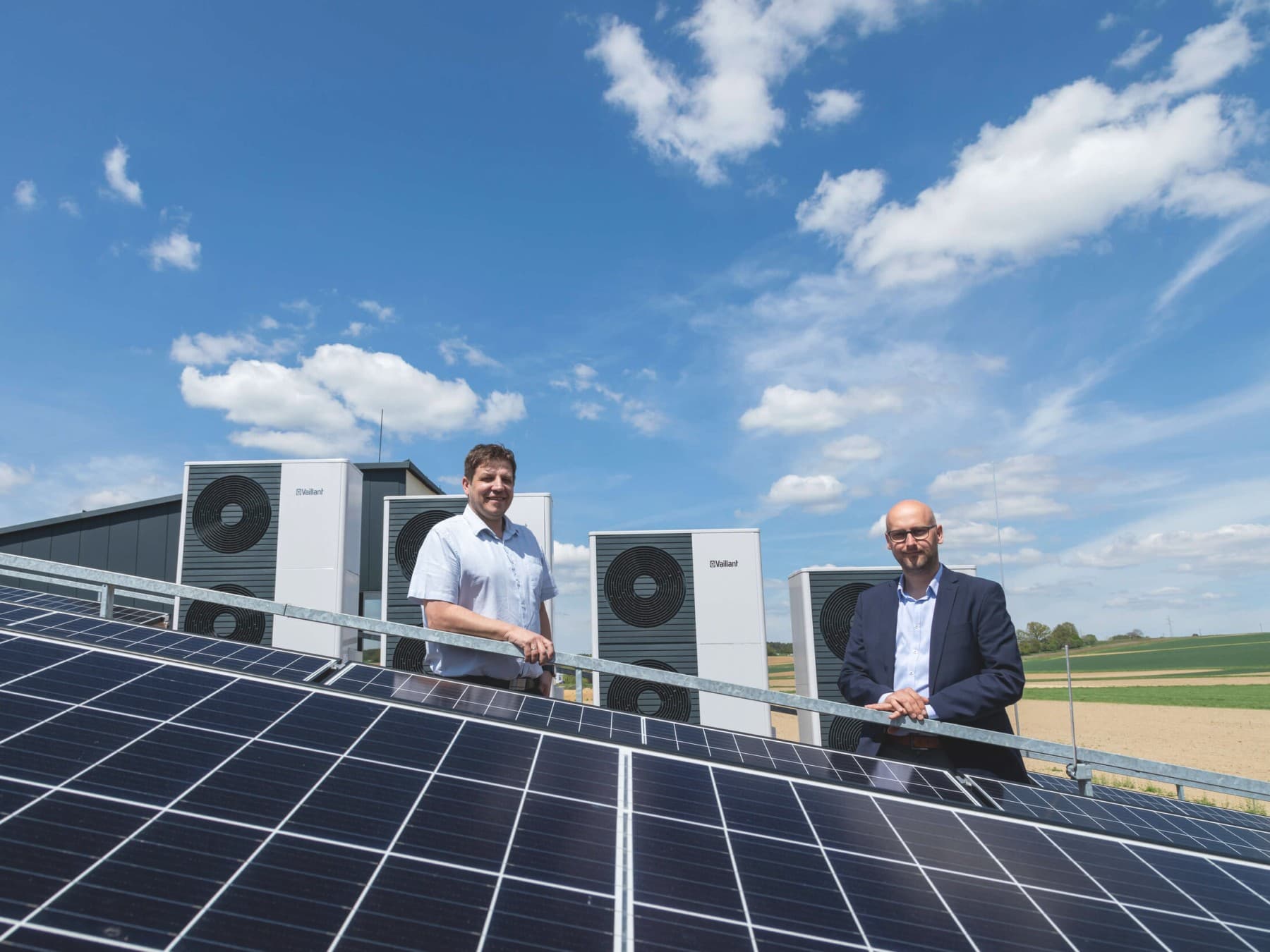 Zwei Männer hinter einer PV Anlage und vor Vaillant Wärmepumpen