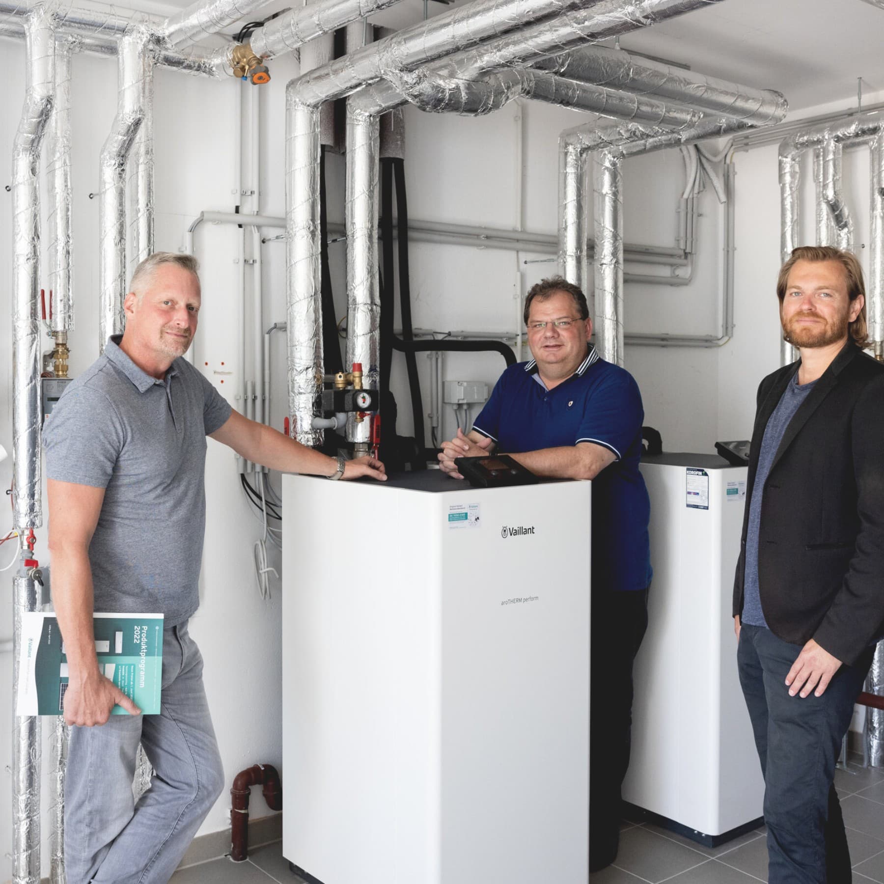 Drei Männer im Heizkeller der Wohnanlage vor einem Vaillantgerät
