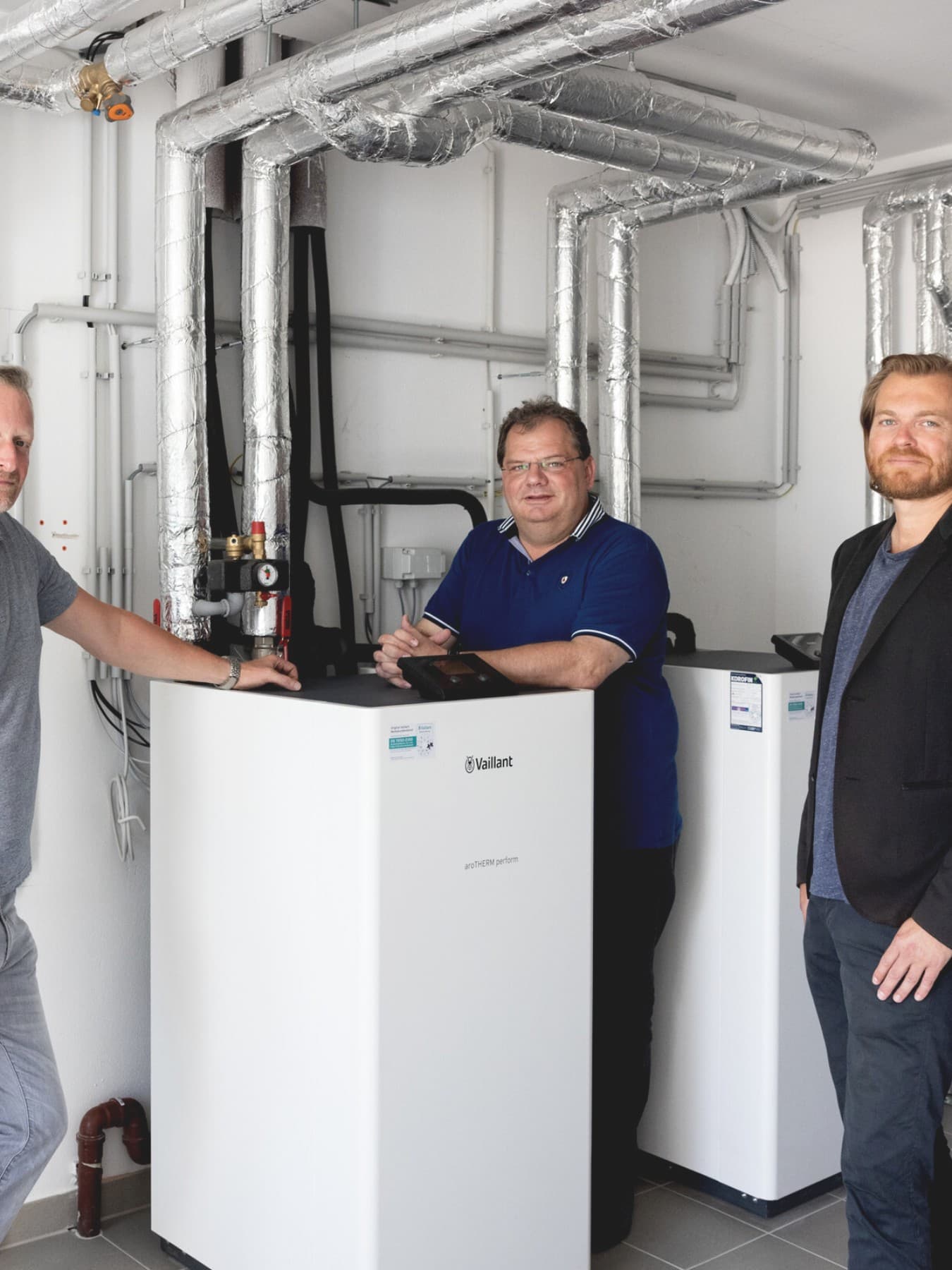 Drei Männer im Heizkeller der Wohnanlage vor einem Vaillantgerät
