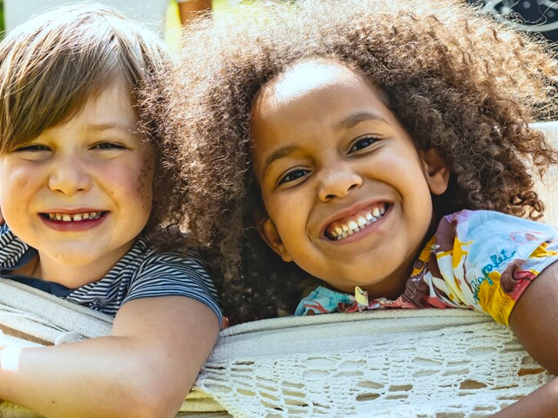 Kinder sitzen in einer Hängematte