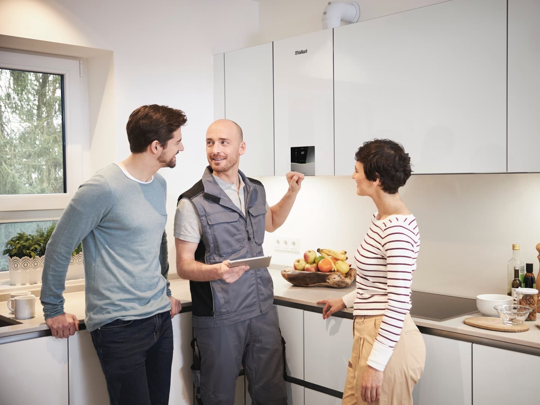 Fachhandwerker erklärt einem Mann und einer Frau ein Vaillant Produkt