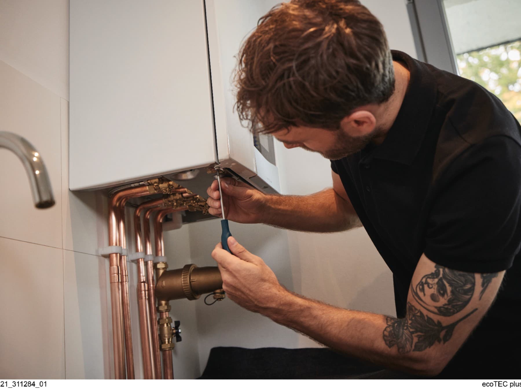 Installateur arbeitet an einem Heizkessel